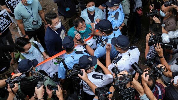 Hong Kong'da Çin İrtibat Ofisi önünde protesto düzenleyenler arasında bulunan demokrasi yanlısı vekil Wu Chi-wai, polisle arbede halindeyken - Sputnik Türkiye