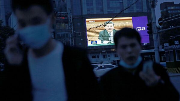 Çin Devlet Başkanı Şi Cinping'in Ulusal Halk Kongresi'nin açılışındaki görüntülerini aktaran dev ekran önünde yürüyen maske takmış Pekinliler - Sputnik Türkiye