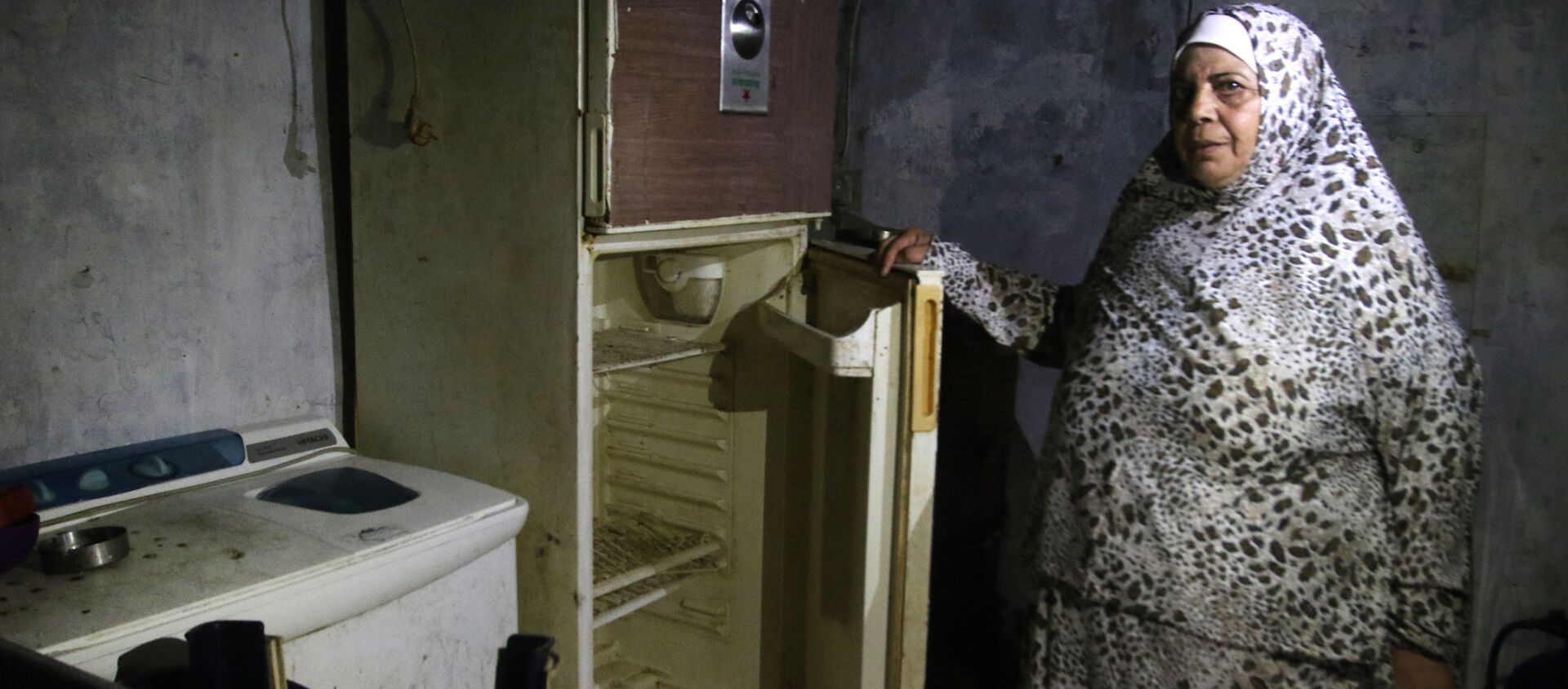 Lübnan'da AFP'nin ziyaret ettiği Sayda kenti sakini bir kadın, buzdolabını açarak içinin bomboş olduğunu gösterdi. - Sputnik Türkiye, 1920, 24.06.2020