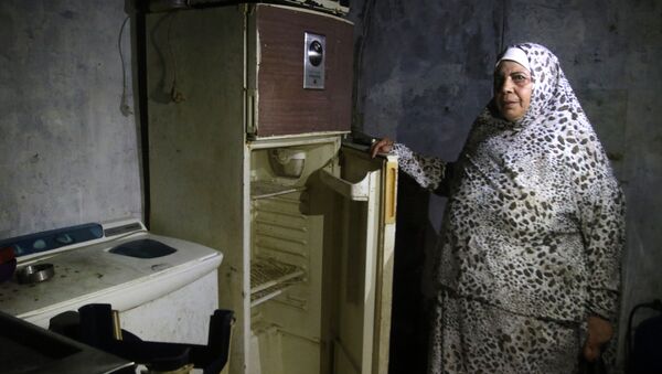 Lübnan'da AFP'nin ziyaret ettiği Sayda kenti sakini bir kadın, buzdolabını açarak içinin bomboş olduğunu gösterdi. - Sputnik Türkiye